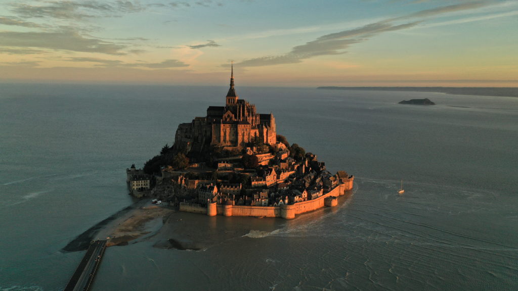An aerial view shows the iconic Mont-Saint-Michel surrounded by sea at sunrise, during the highest tide of the year