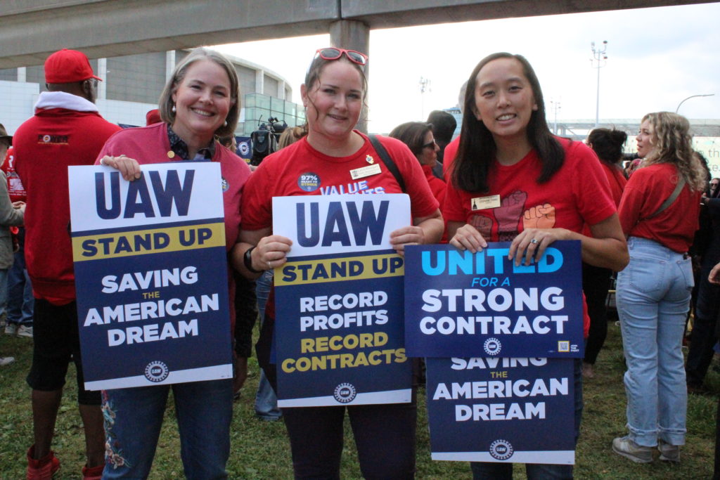 Democrats Michigan Sen. Sue Shink, Rep. Carrie Rheingans, and Sen. Stephanie Chang at the UAW’s “Stand up for our Communities against Corporate Greed” rally in Detroit. September 15, 2023. Photo by Frances Kai-Hwa Wang for the PBS NewsHour