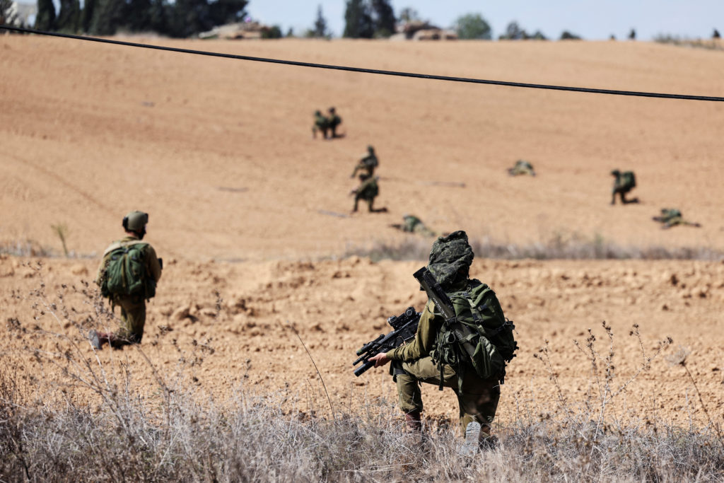 Israeli soldiers take position at Kibbutz Kfar Aza, in southern Israel