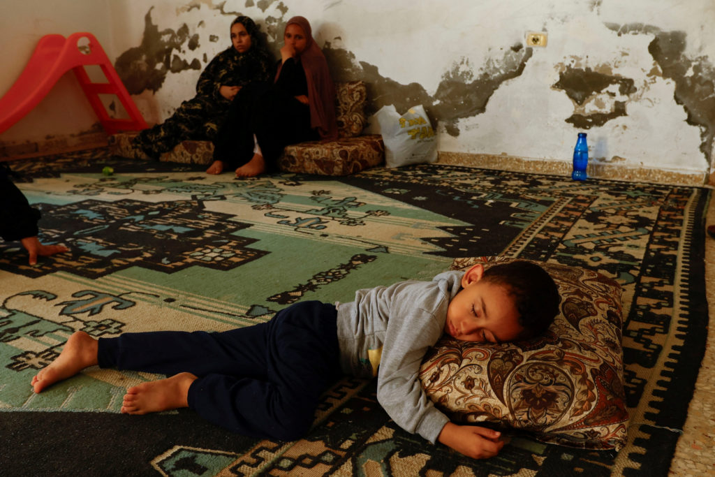 Palestinian woman Samah Abu Latifa, who fled her home amid Israeli strikes, shelters with her family in a kindergarten
