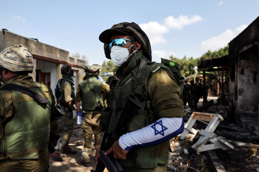 An Israeli soldier wears a mask as he looks on following an attack by Gazan militants on Kibbutz Kfar Aza, in southern Israel, October 10, 2023. Photo by Violeta Santos Moura/REUTERS