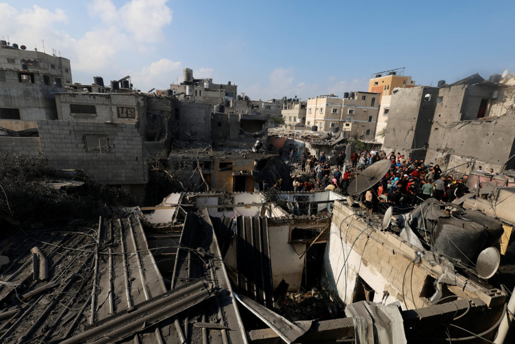Palestinians inspect the site of Israeli strikes on houses