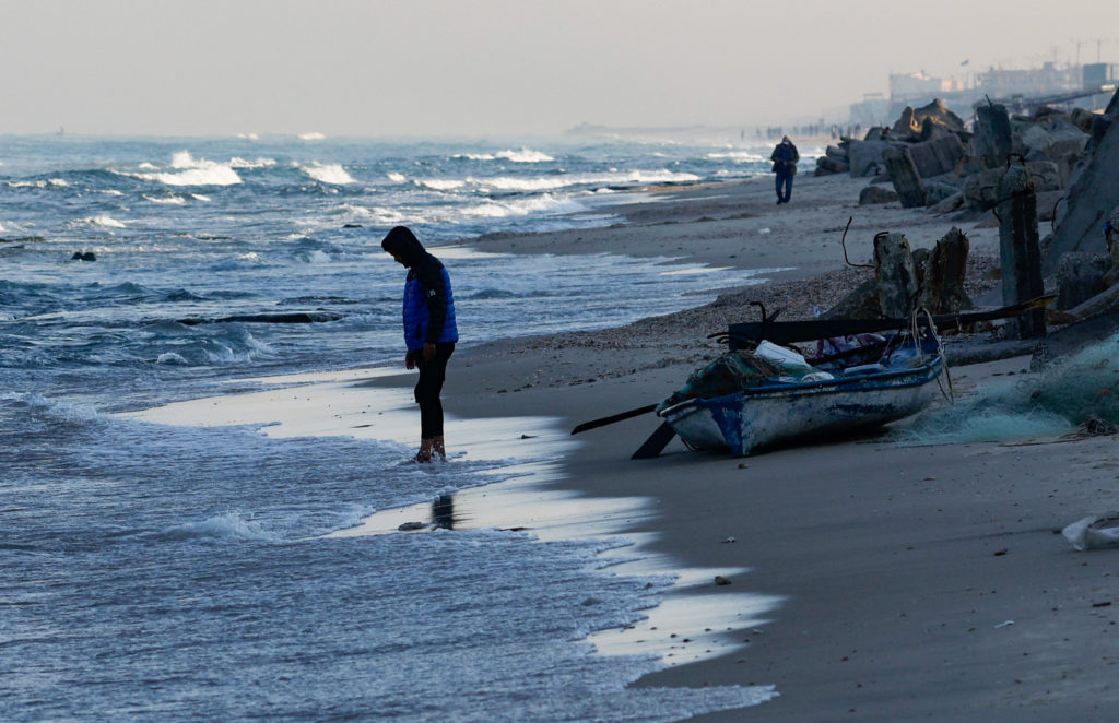 A person stands in front of a fishing boat at the beach, amid the ongoing conflict between Israel and Palestinian Islamist group Hamas, in Rafah, in the southern Gaza Strip, January 16, 2024. Photo by Mohammed Salem/REUTERS