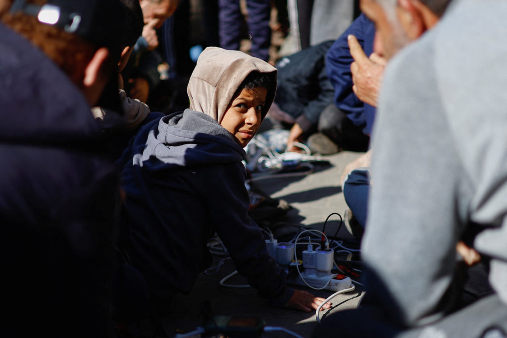 A child reacts as Palestinians charge their devices outside the Emirati hospital, amid the ongoing conflict between Israel and the Palestinian Islamist group Hamas, in Rafah in the southern Gaza Strip, January 15, 2024. Photo by Ibraheem Abu Mustafa/REUTERS