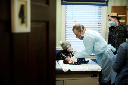 Dr Greg Gulbransen performs a nasal swab on a 13-day-old newborn whose parents have tested positive for the coronavirus di...