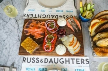 A spread of bread, cheese, and assorted foods displayed on a table at Russ & Daughters Cafe