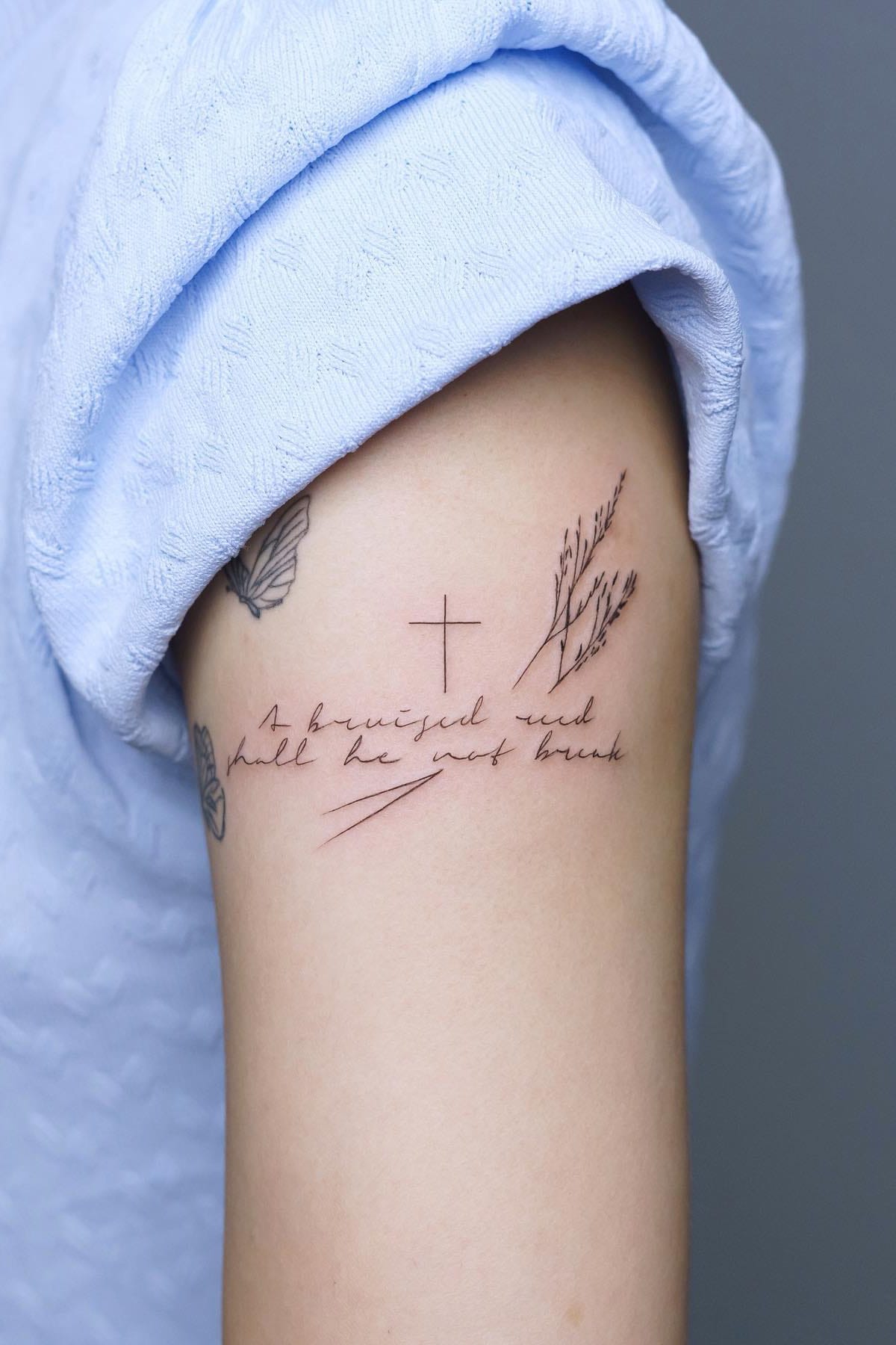 Small cross tattoo on arm