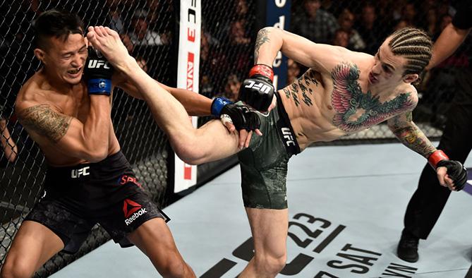 LAS VEGAS, NV - MARCH 03:   (R-L) Sean O'Malley kicks Andre Soukhamthath in their bantamweight bout during the UFC 222 event inside T-Mobile Arena on March 3, 2018 in Las Vegas, Nevada. (Photo by Jeff Bottari/Zuffa LLC/Zuffa LLC via Getty Images)