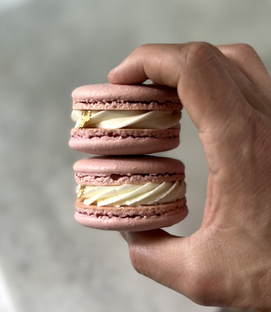 holding two Macaron filled with lavender ermine buttercream