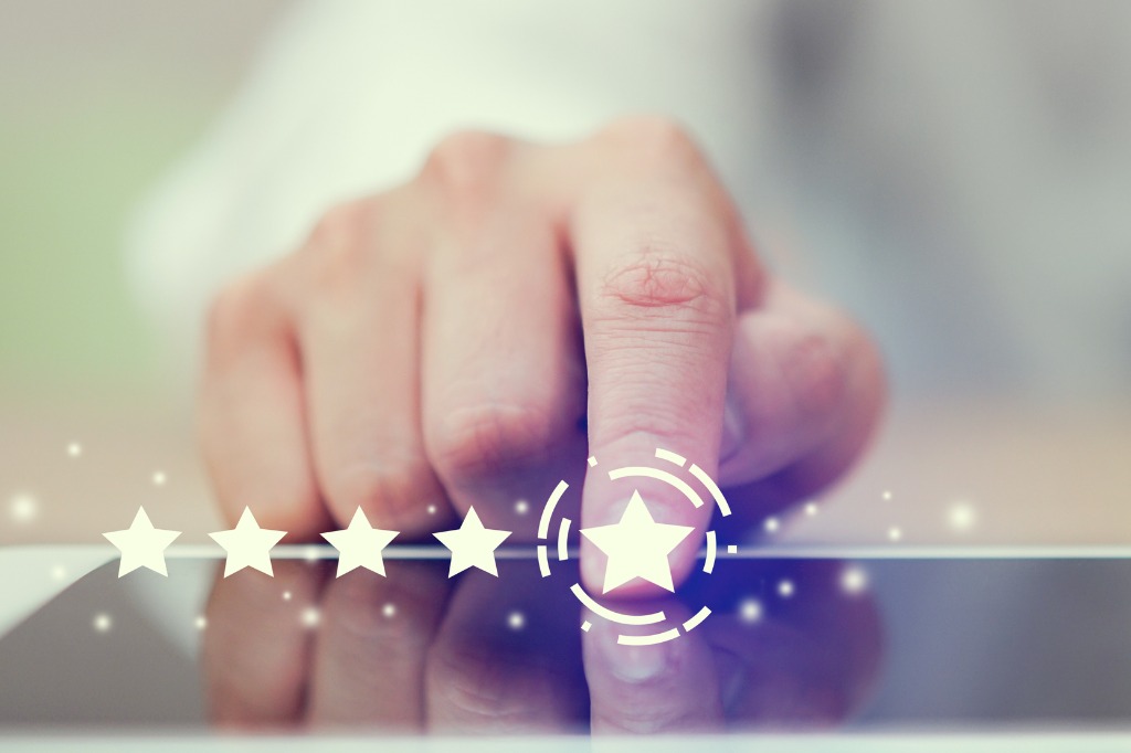 Close-up na mão do empresário pressionando a tela do tablet digital com feedback de classificação de cinco estrelas para dar um excelente conceito de trabalho do varejo do futuro.