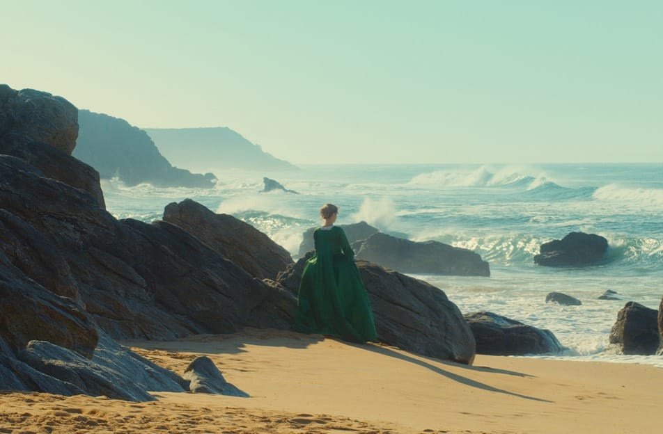 Adele Haenel standing on a deserted beach looking out to sea