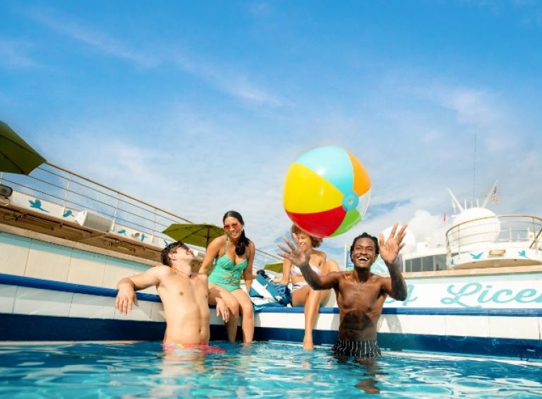 A Group Of People Playing With A Ball In A Pool