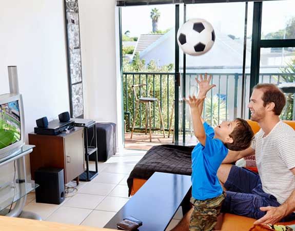 Visually impaired father and son watch the World Cup on their TV