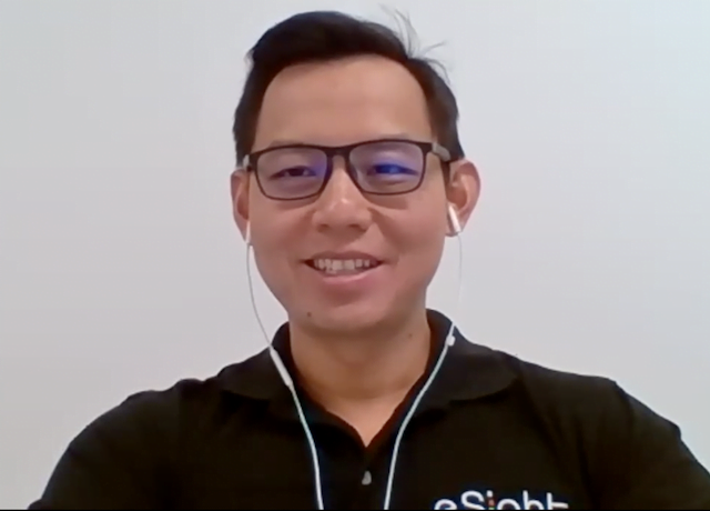 Charles Lim smiling a camera while speaking to low vision specialsits about the new esight 4