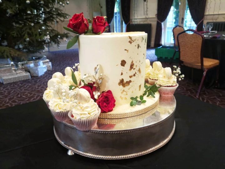 wedding cake with roses and cupcakes