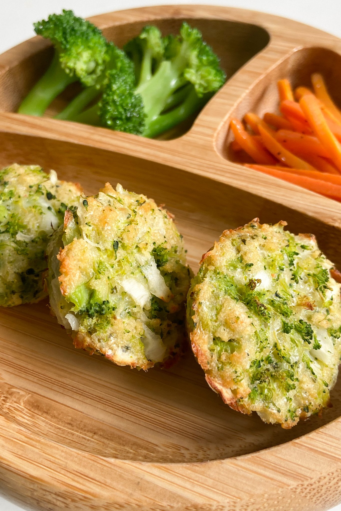 Broccoli and cheese bites served with broccoli and sliced carrots