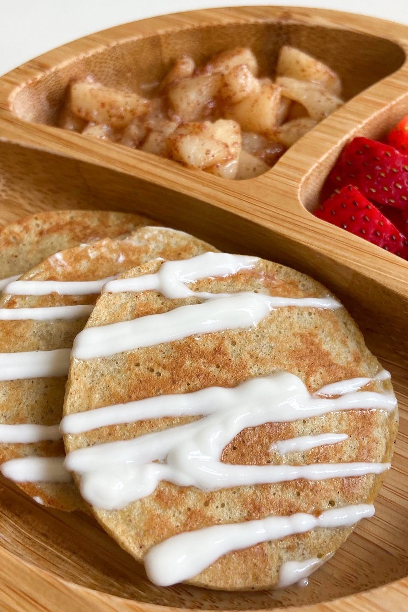 Pear pancakes drizzled with yogurt. Served with cinnamon pears and strawberries