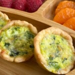 Mini spinach quiche served with raspberries and mandarins