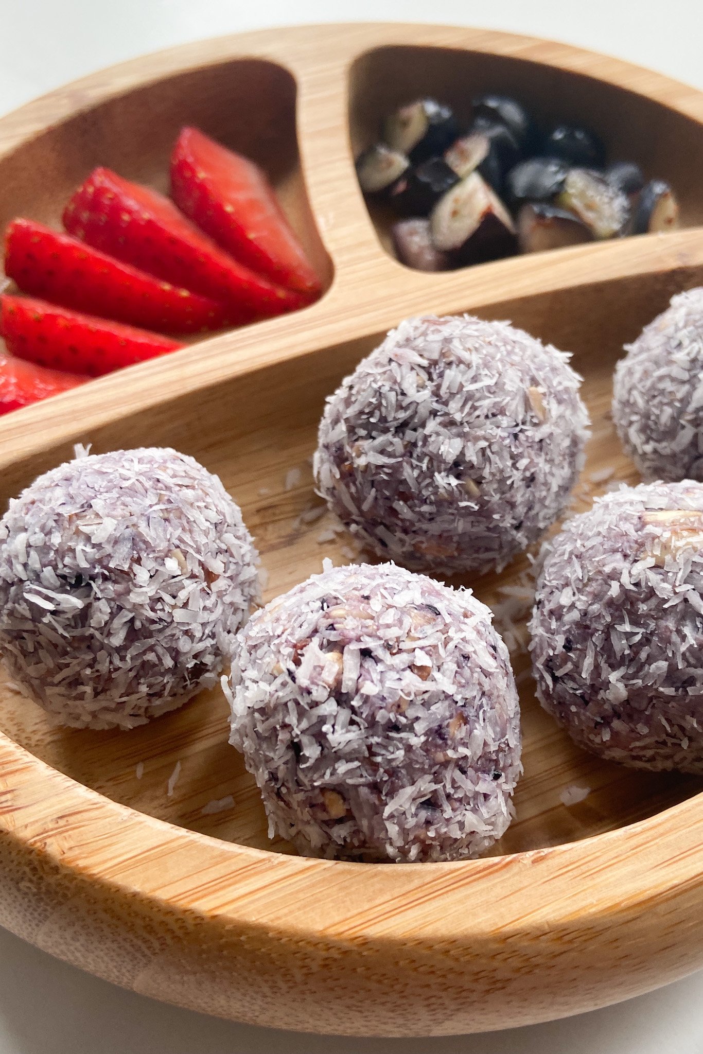 Blueberry bliss balls served with sliced strawberries and blueberries