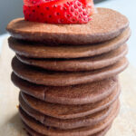 Chocolate banana pancakes topped with sliced strawberries