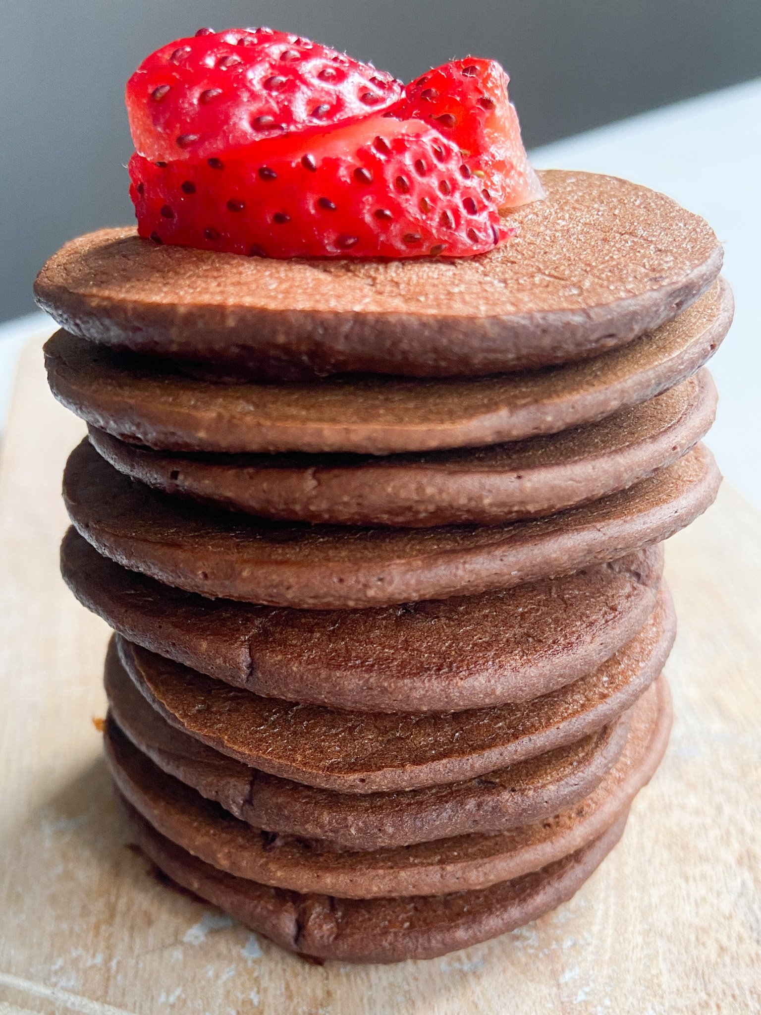 Chocolate banana pancakes topped with sliced strawberries