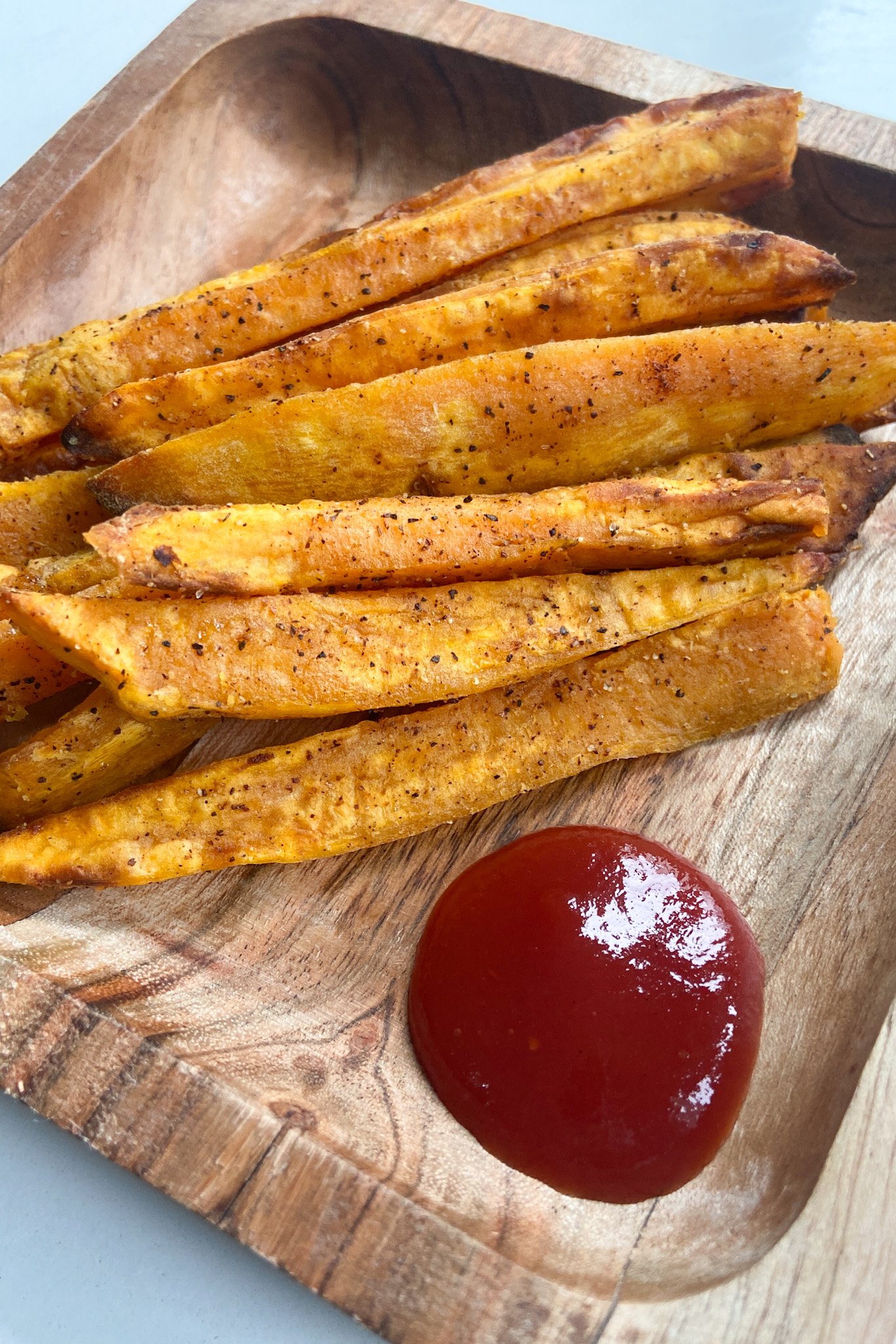 Air fryer sweet potatoes served with a side of ketchup