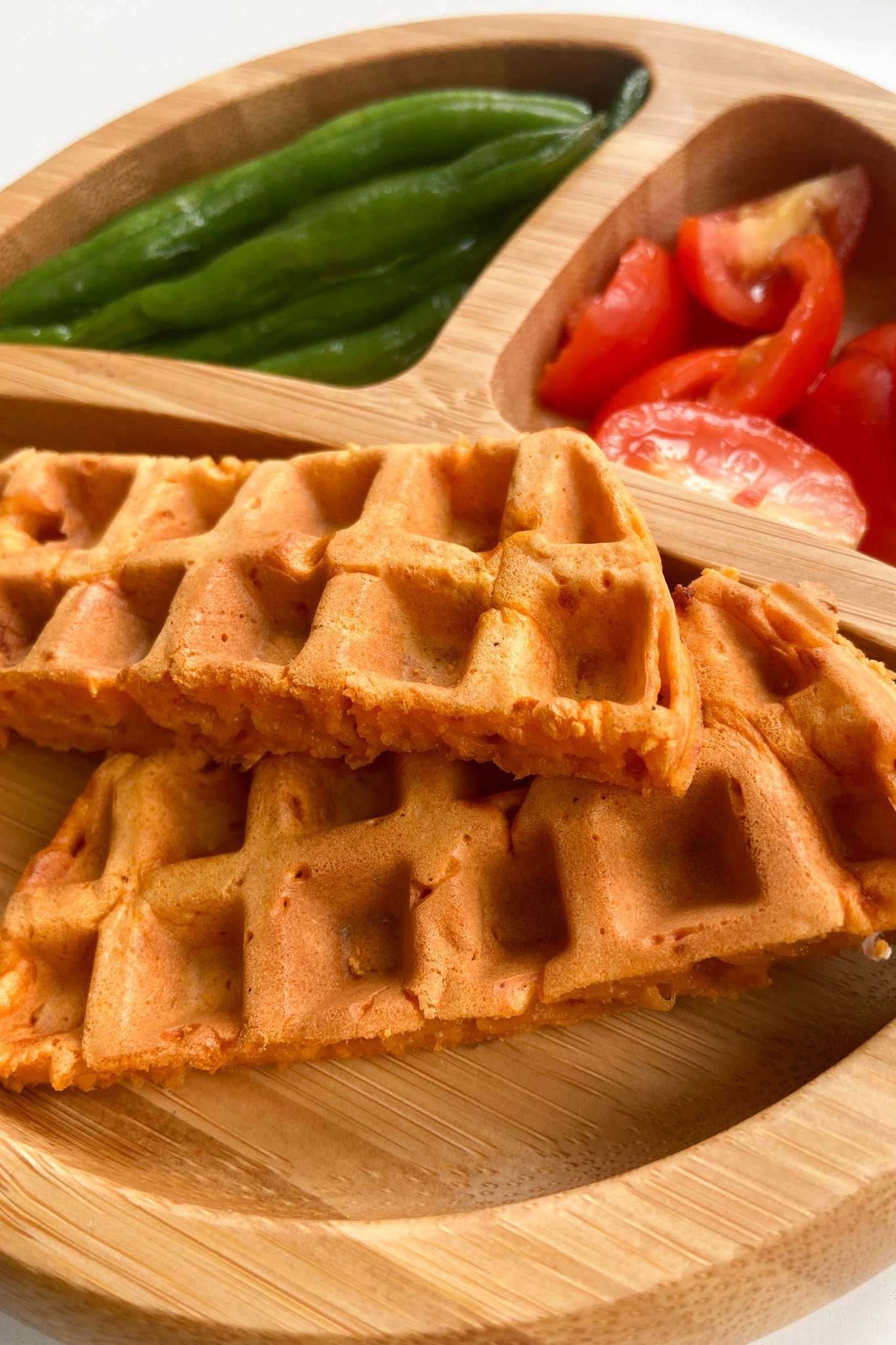 Pizza waffles served with green beans and quartered tomatoes