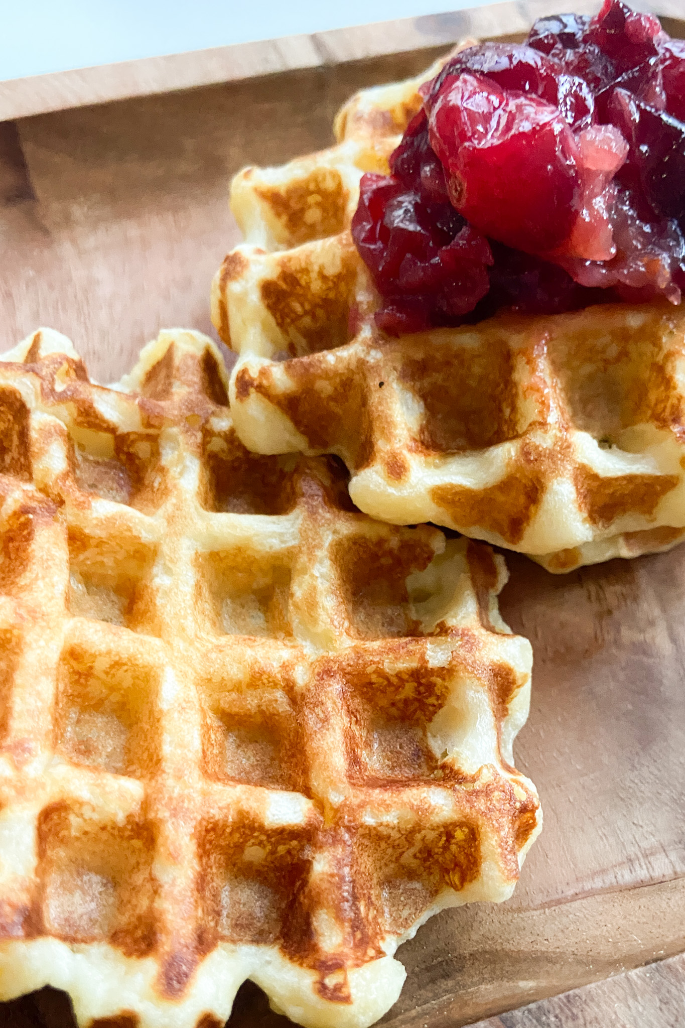 Mashed potato waffles topped with crushed cranberries.