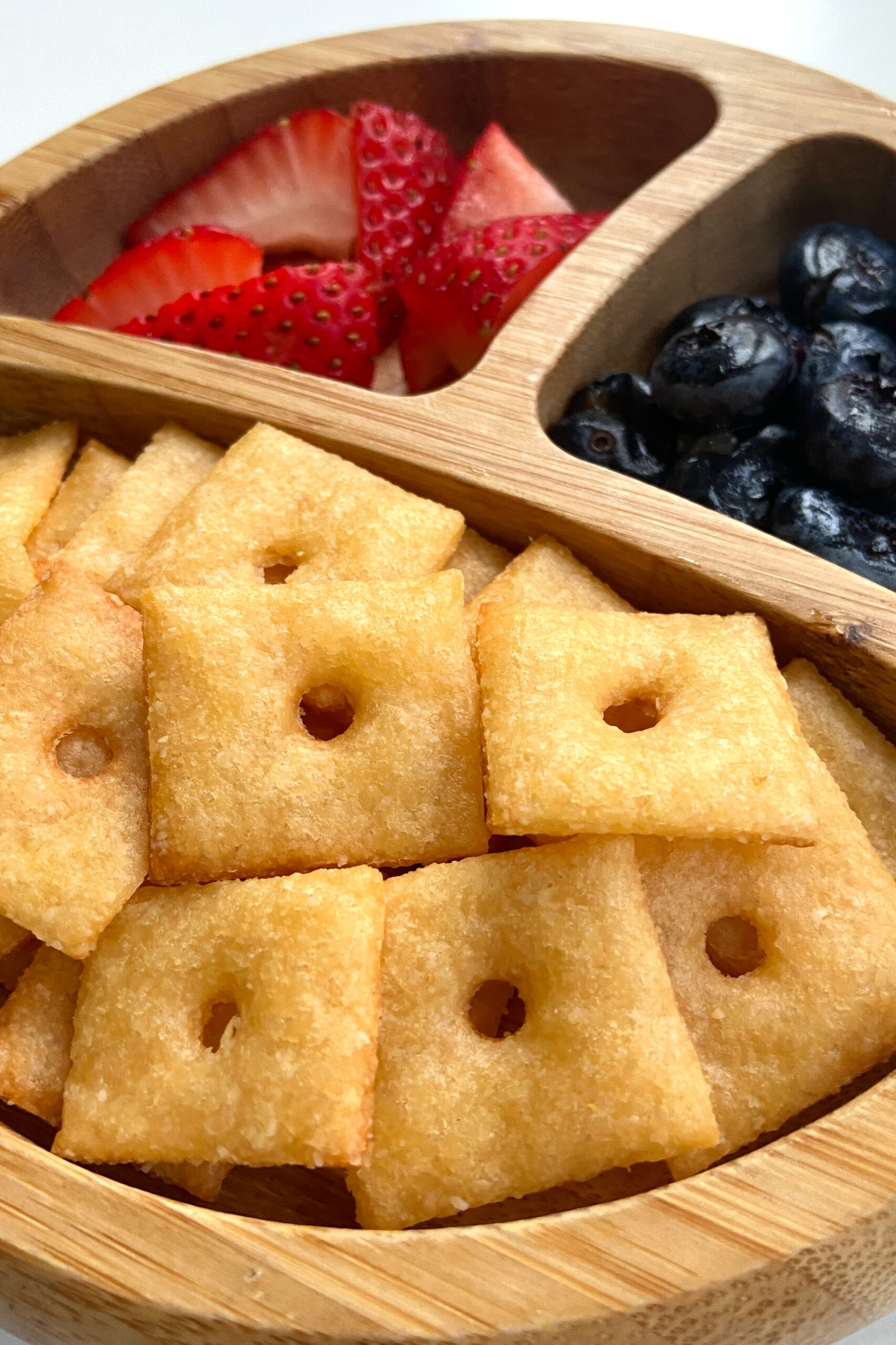Homemade cheez-it crackers served with strawberries and blueberries