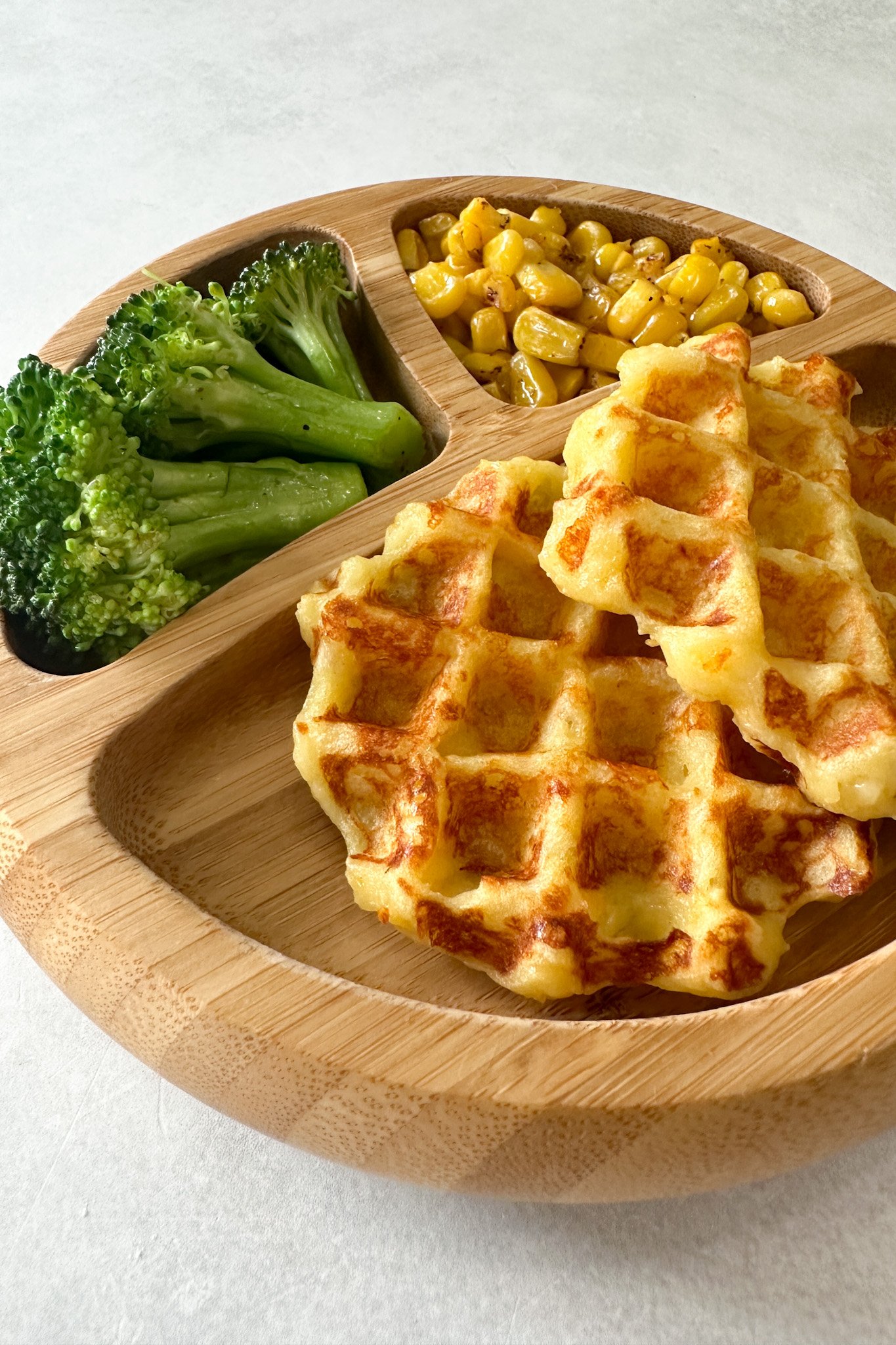 Leftover mashed potato waffles served with broccoli and corn.