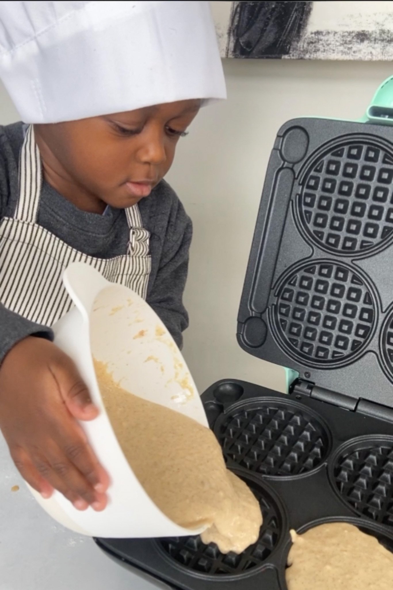 Toddler making waffles.