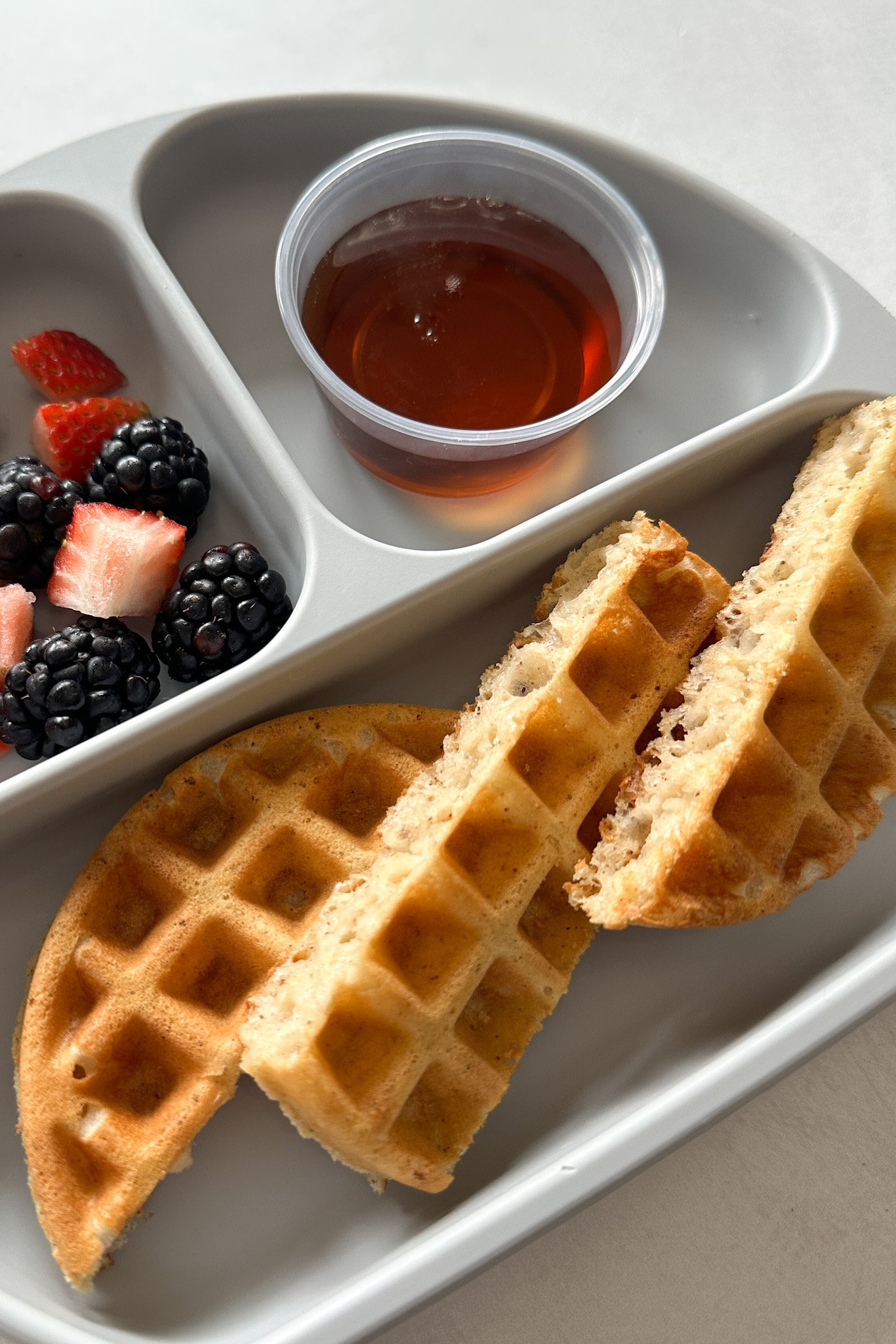 Eggless waffles served with berries and maple syrup.