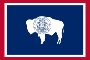 Die Flagge von Wyoming zeigt auf blauem Hintergrund das Siegel des Staates in der Mitte. Das Siegel enthält eine bunte Landschaft mit Bergen, einem Fluss und einem Tal, daneben zwei Cowboys. Oberhalb des Siegels steht der Schriftzug 'State of Wyoming' und darunter das Motto 'Equal Rights' (Gleiche Rechte). Die Flagge würdigt die Naturschönheiten und das Erbe des Bundesstaates Wyoming.