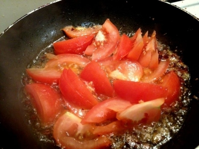 Cho cà chua và dứa vào đảo đều và cho thêm 1,5 lít nước sạch vào nồi đun