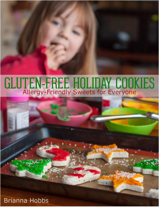 December 2021 GfreeCookbook Club selection cover Gluten-Free Holiday Cookies: Allergy-Friendly Sweets for Everyone. Cover features an iconic scene of a little girl overlooking a counter of decorated Christmas cookies.