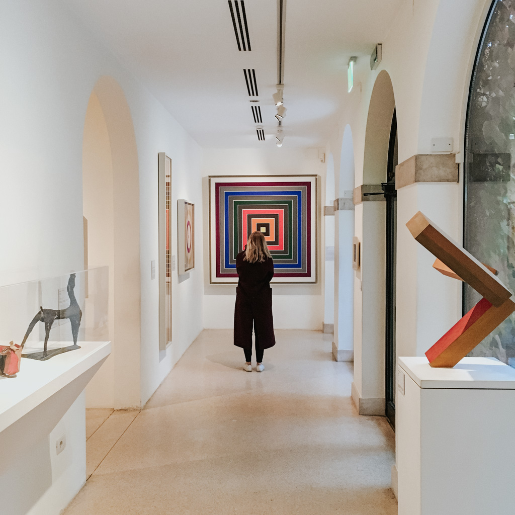 girl in black coat strolls the halls of the Peggy Guggenheim on Venice in 2 days