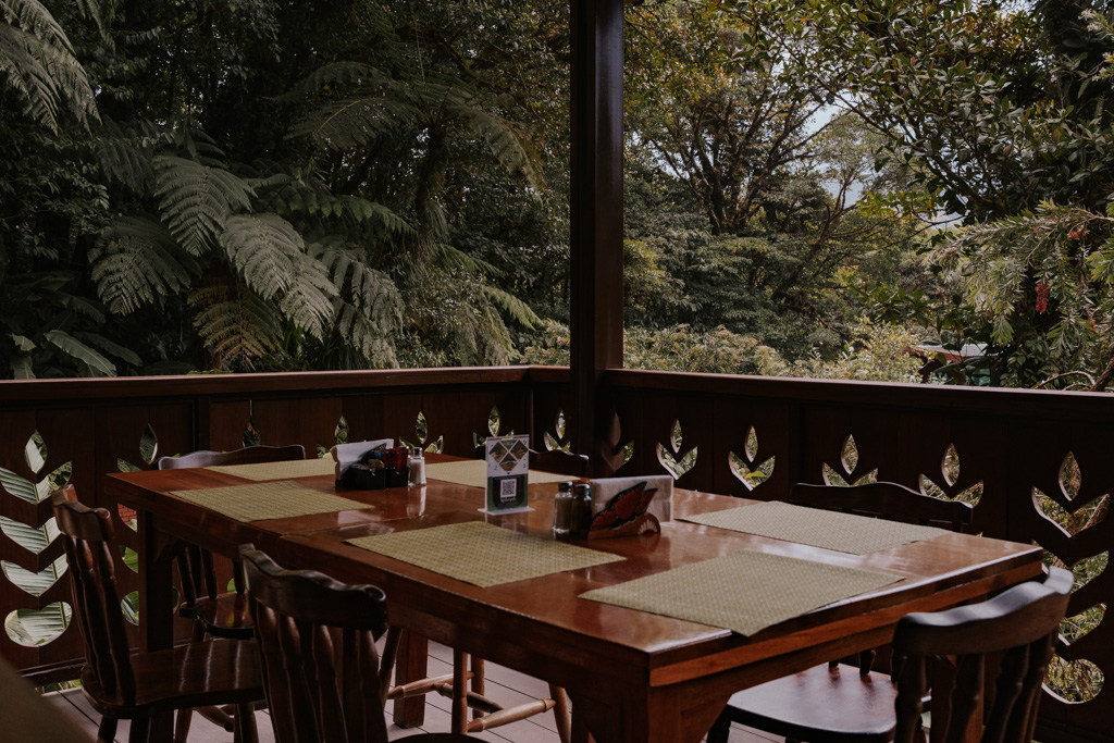 wood table and chairs with placemats and view of greenery at Selvatura Park restaurant