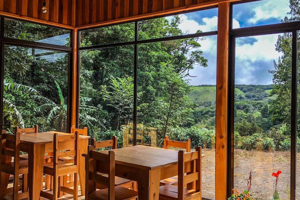 a wood dining room with floor to ceiling windows at Tityra Monteverde hotels