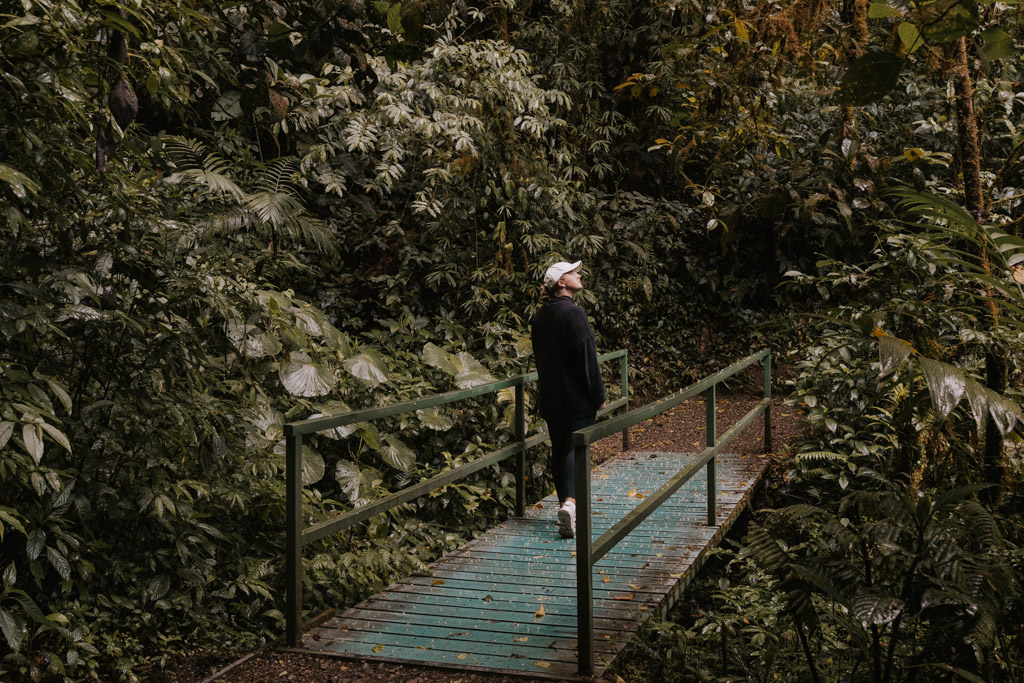 woman walking across small wooden bridge in Monteverde Costa Rica