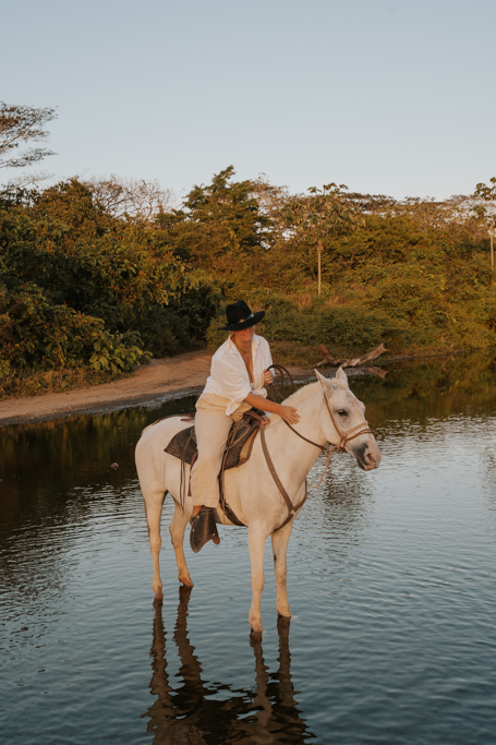 woman on a horse in the water near st teresa costa rica