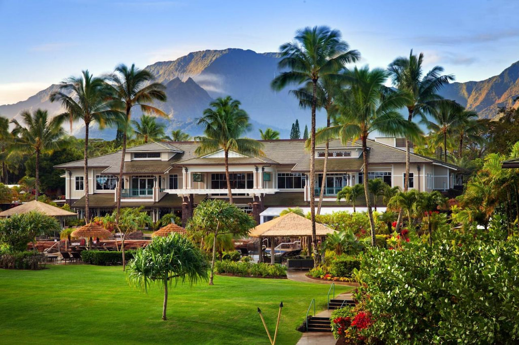 Kauai luxury resort hidden away behind palm trees with stone path in the foreground
