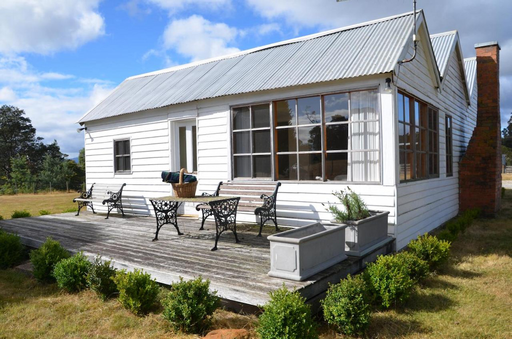 white painted cabin with patio near Cradle Mountain