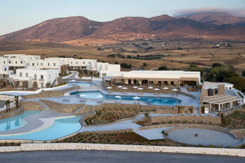 birds eye view of large resorts in Paros Greece with large organic shaped pools and square white buildings
