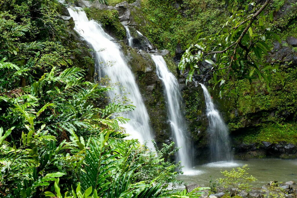tiered waterfall falling into a lagoon surrounded by greenery an excursion you can take from the top hotels in Kauai