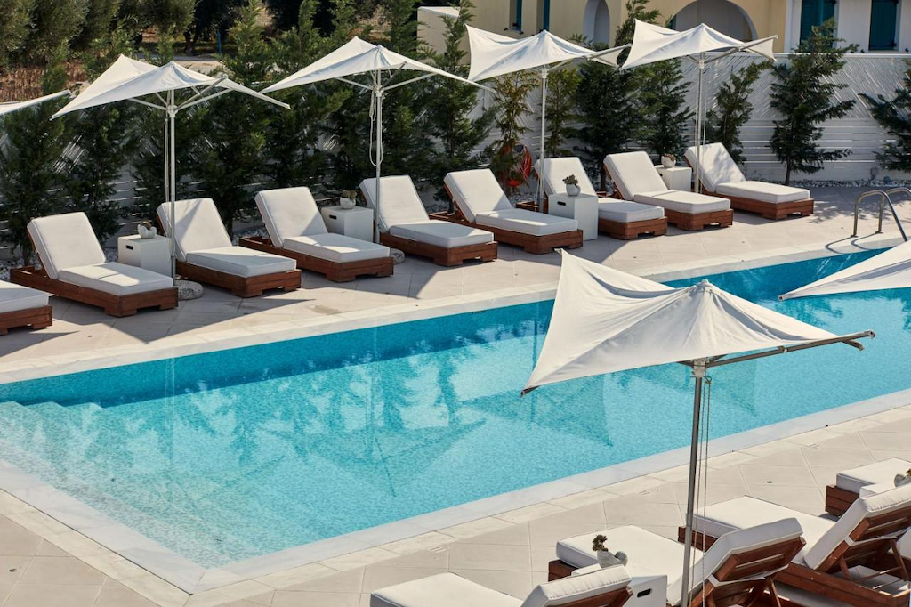 a close up of the blue rectangular pool at 18 Grapes Hotel Naxos with white furniture