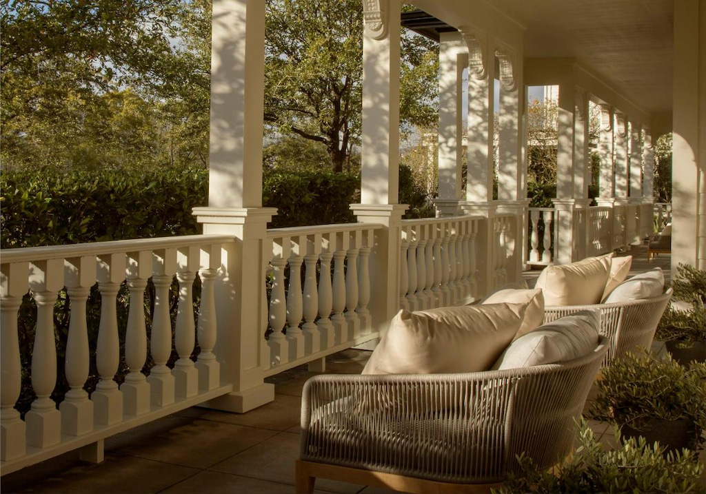 Comfy chairs with white pillows on the balcony of MacArthur Place.