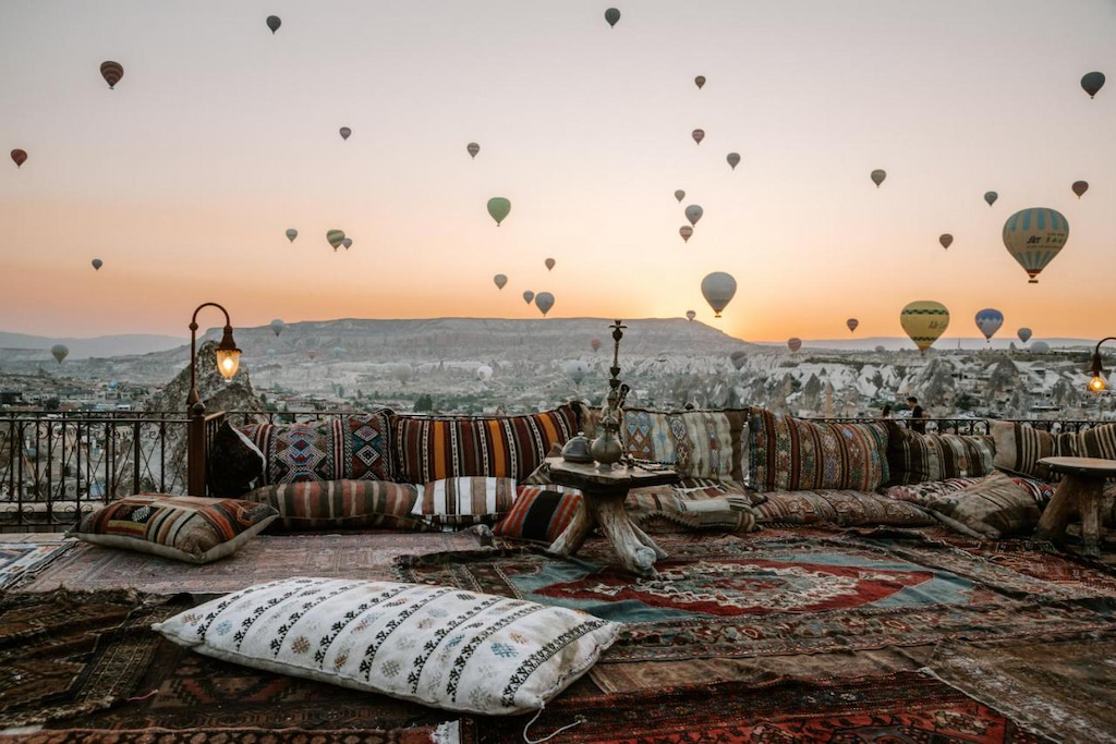 expansive cushioned seating on a terrace to see balloons in the distance at a Cappadocia hotel