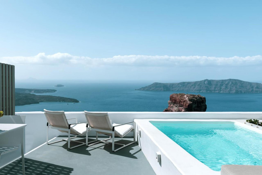 View from the balcony of one of the rooms in Grace Hotel with white benches and a private pool for the guests - an amazing spot to witness the beautiful islands in Greece