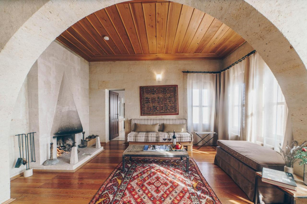 Large airy Cappadocia 5 star hotels with arched stone ceiling, large Turkish rug and living room furniture