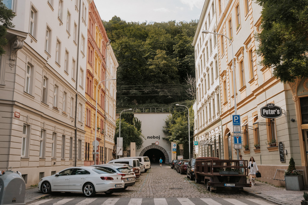 street scene with parked cars, tunnel and greenery in Karlin one of the best neighborhoods in Prague
